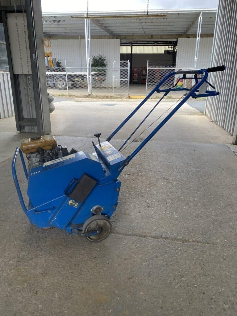 A Blue Lawn Mower is Parked on the Sidewalk in Front of a Building — Hamblin Hire in Albury, NSW