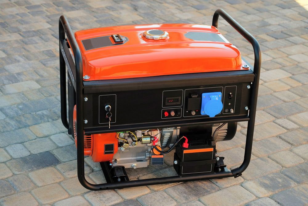 An Orange Generator is Sitting on a Brick Sidewalk — Hamblin Hire in Albury, NSW