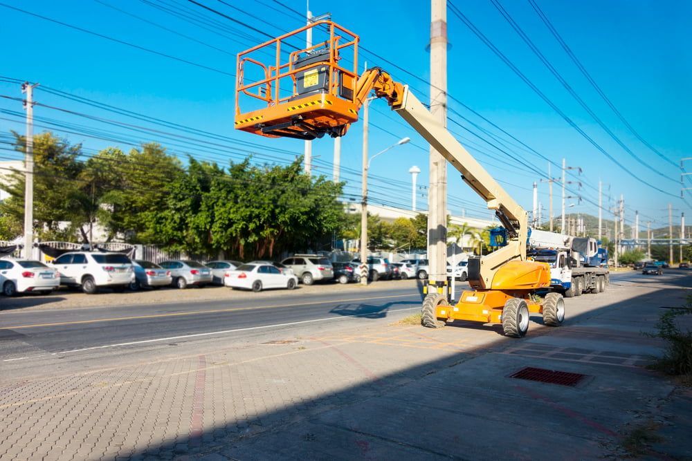A Man is Working on a Pole With a Crane in a Parking Lot — Hamblin Hire in Albury, NSW