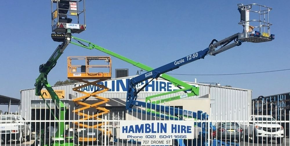 A Man is Standing in a Bucket on a Lift in Front of a Building — Hamblin Hire in Albury, NSW