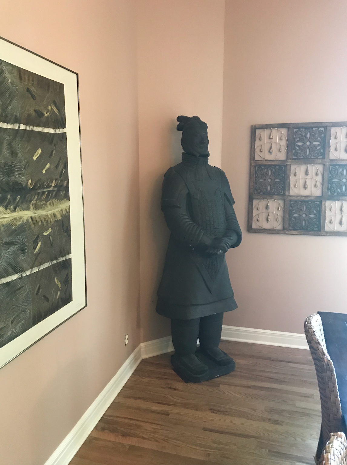 A statue of a man is standing in the corner of a room