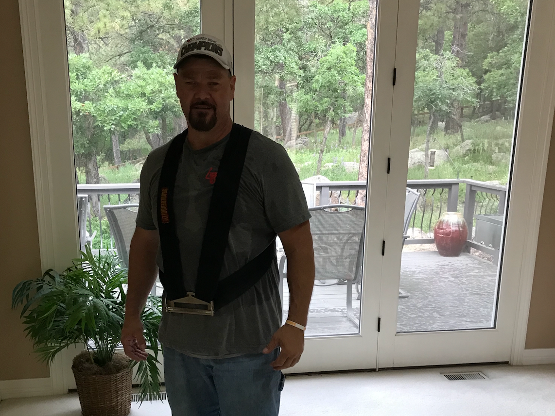 Two Delivery Men Are Carrying A Cardboard Box To A Truck