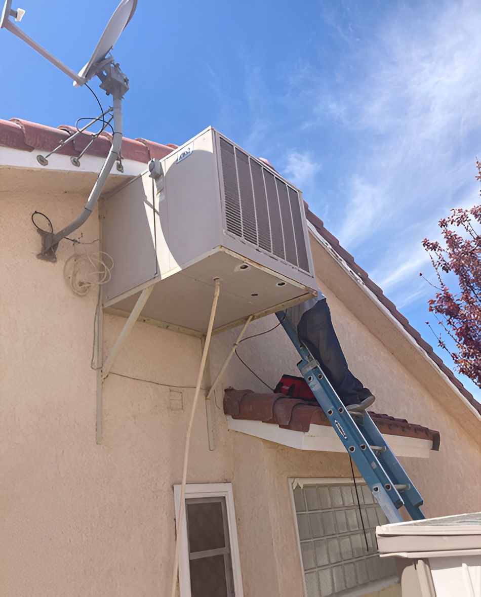 Person on ladder working on an air conditioning unit mounted on a building's exterior wall, satellite dish nearby.
