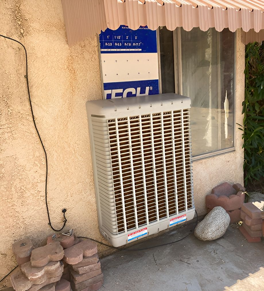 A large, beige evaporative cooler mounted outside a building, next to a window.