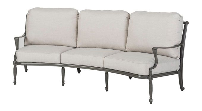 A curved couch with white cushions on a white background.