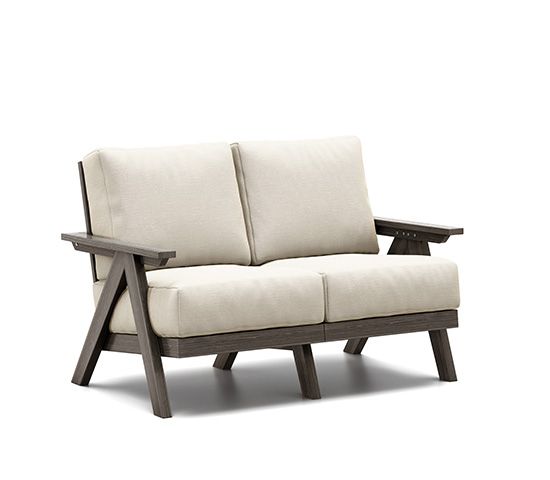 A wooden couch with white cushions on a white background.