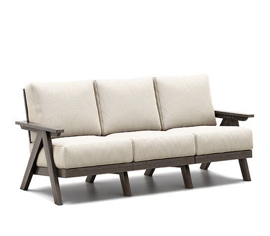 A couch with white cushions and wooden legs on a white background.