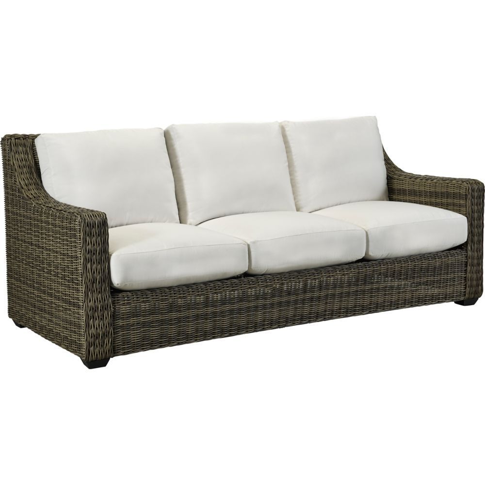 A wicker couch with white cushions on a white background.