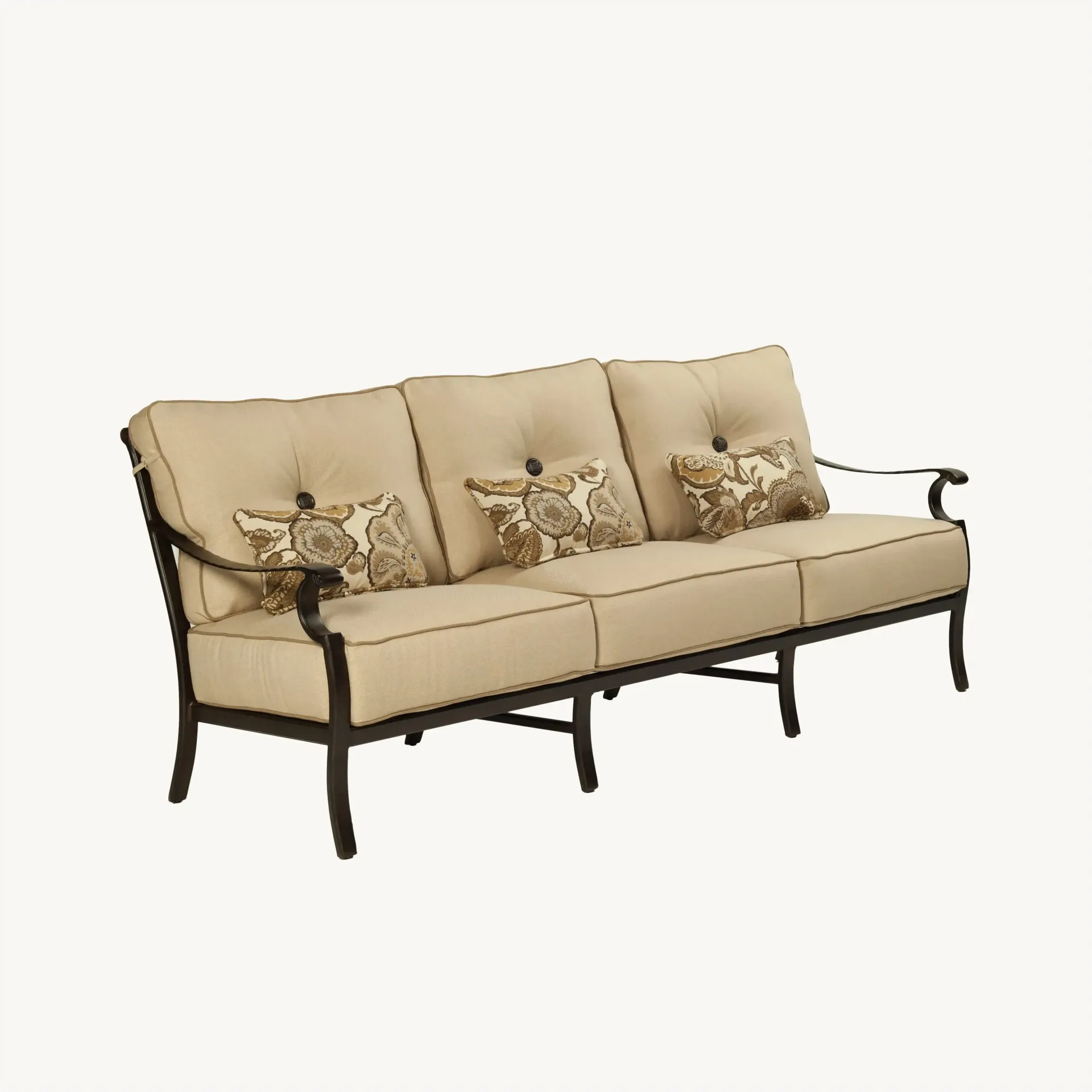 A long beige couch with pillows on a white background.