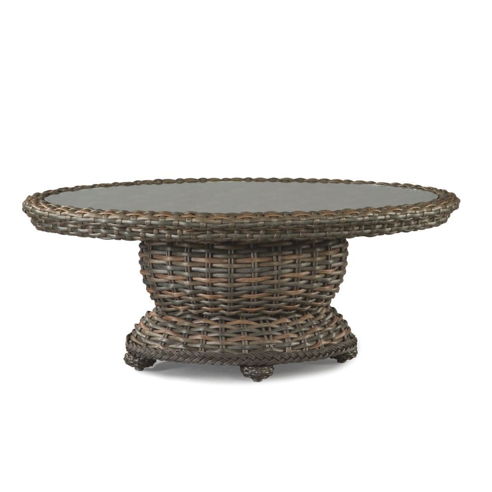 A wicker table with a glass top on a white background