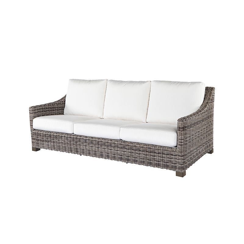 A wicker couch with white cushions on a white background.