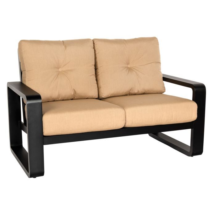 A black couch with tan cushions on a white background