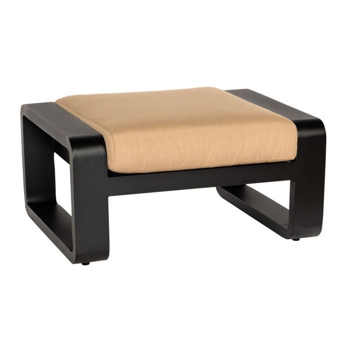 A black ottoman with a tan cushion sits on a white background