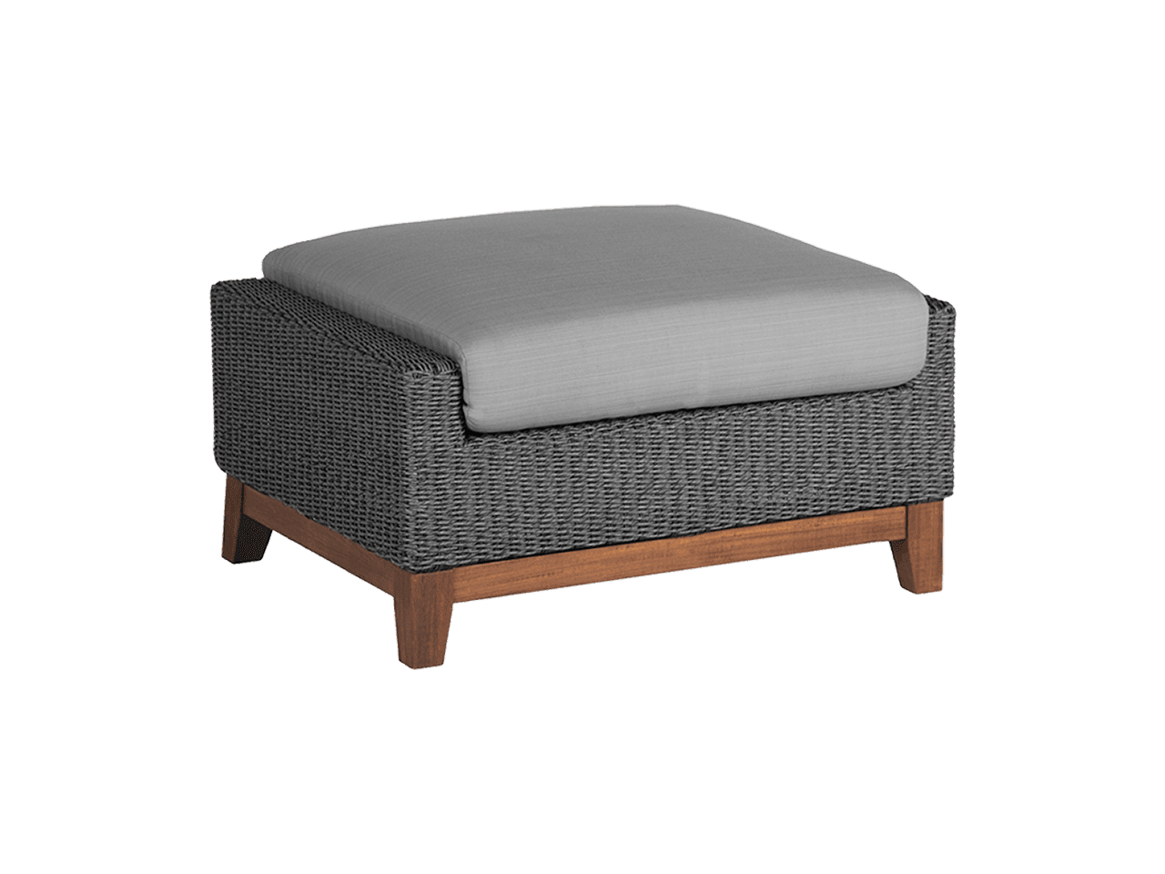 A wicker ottoman with wooden legs and a grey cushion on a white background.