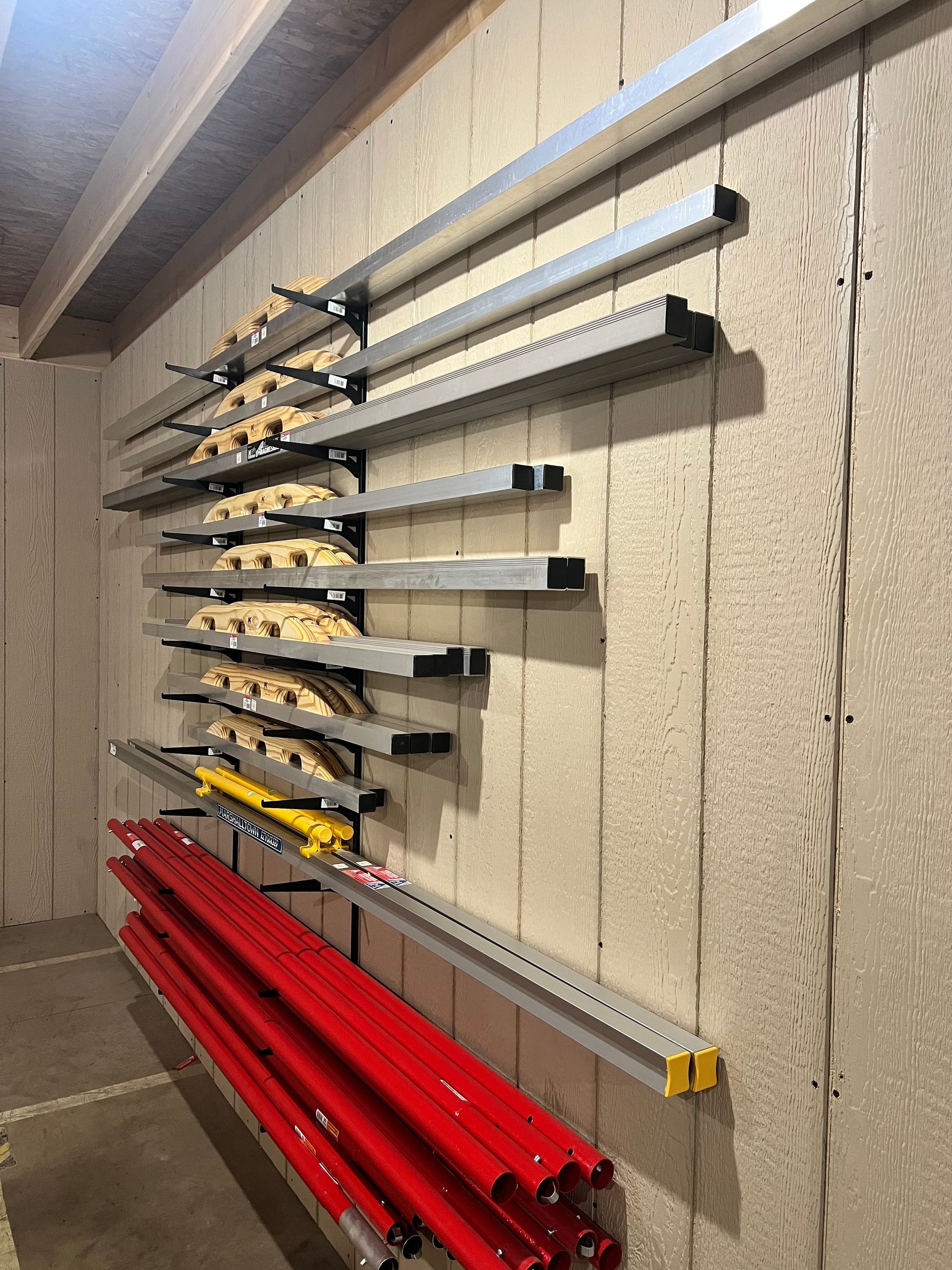 Metal shelving on concrete wall holding construction materials.
