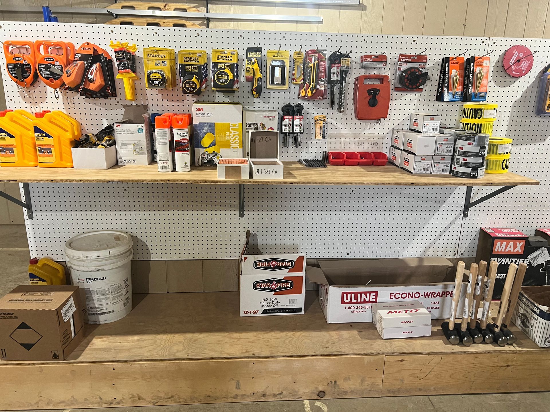 Tools and supplies displayed on shelves and pegboard in a shop setting.