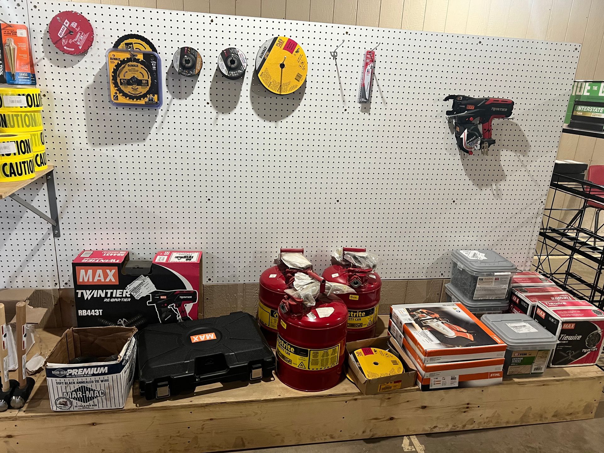 Tools and equipment on display in a store, including boxes, canisters, and items hanging on a pegboard.