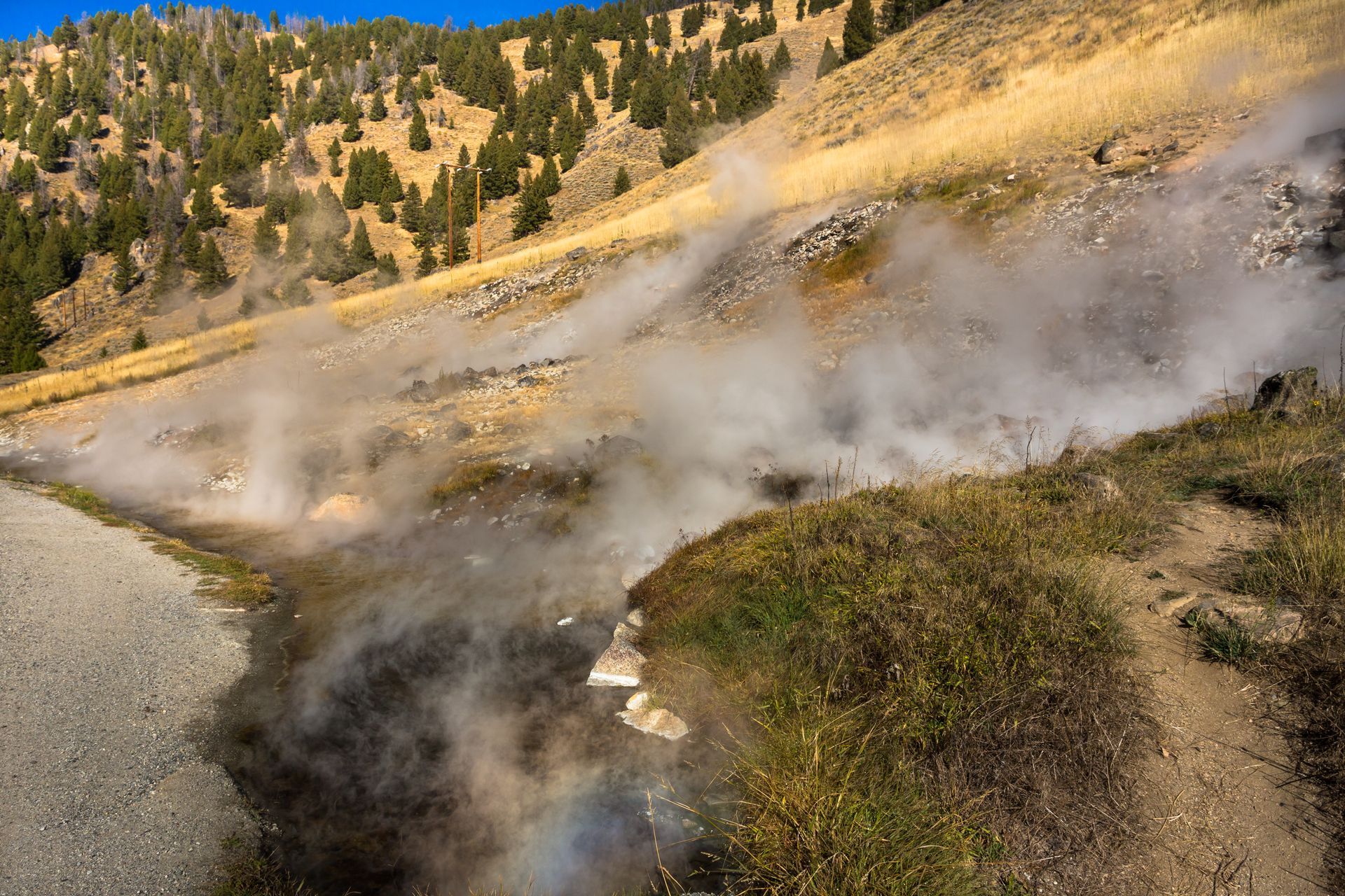 A road in the mountains with smoke coming out of it.