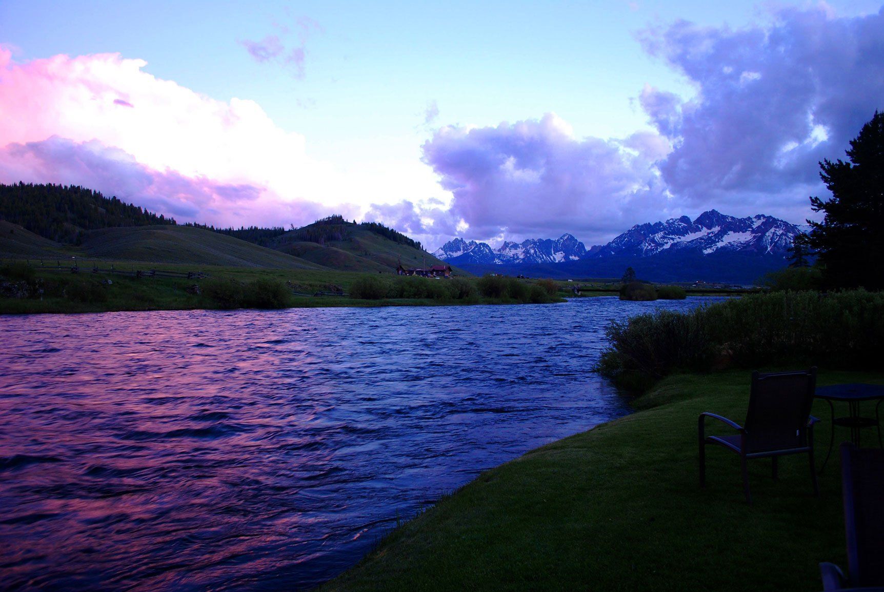 A lake with mountains in the background at sunset