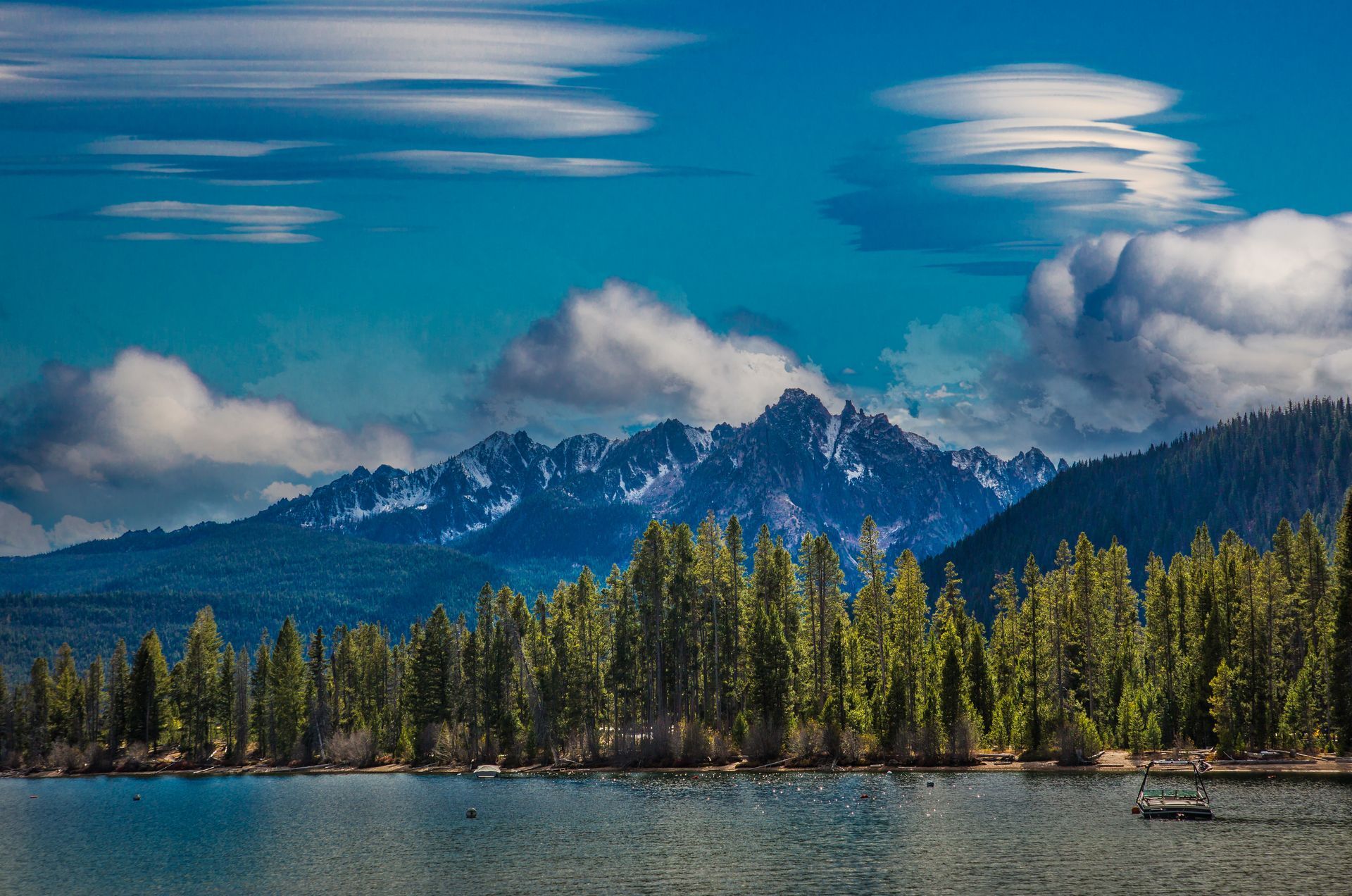 A lake with mountains in the background and trees on the shore