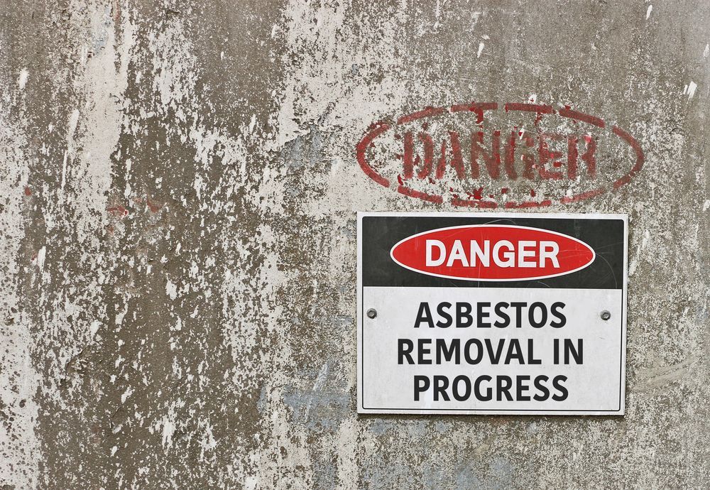 Danger Sign Reading Asbestos Removal In Progress On A Wall — Dirt Werx in Fingal Bay, NSW