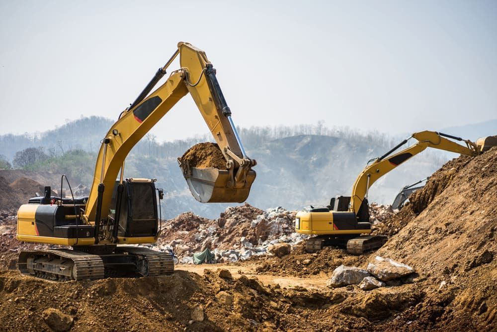 Two Yellow Excavators Working on a Construction Site, Scooping and Moving Dirt — Dirt Werx in Nowra, NSW