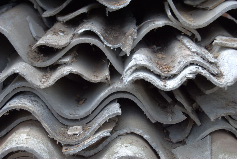 Stacked Gray Corrugated Roof Sheets With Traces Of Asbestos — Dirt Werx in Port Stephens, NSW
