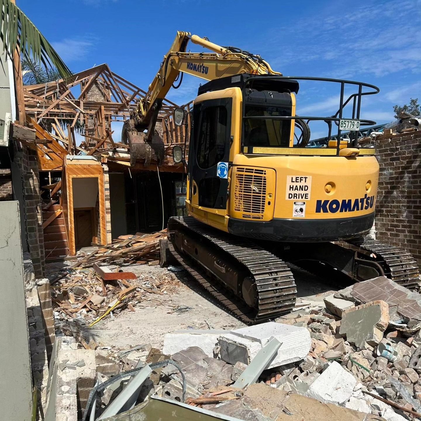 Yellow Excavator Demolishing a House
