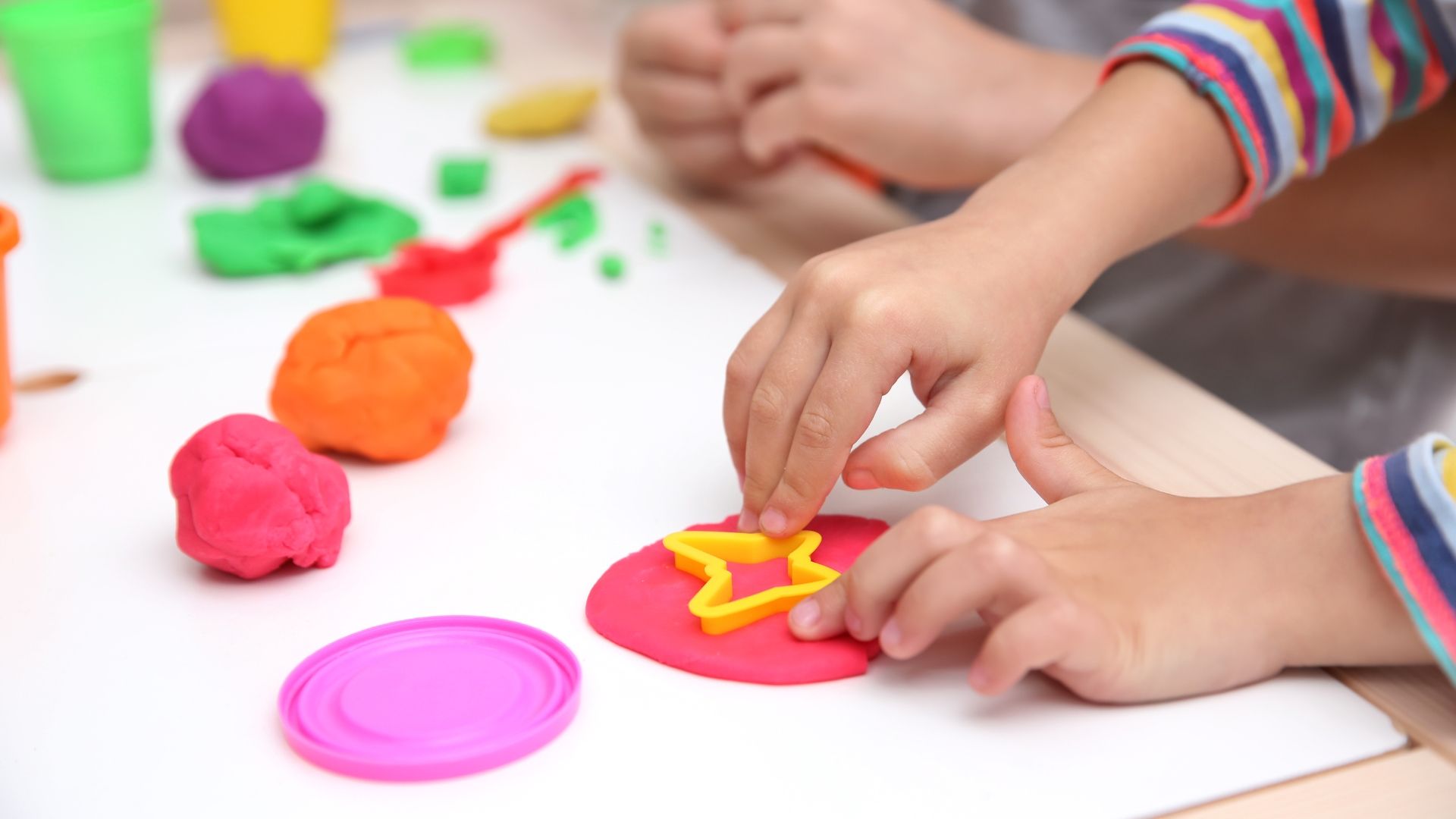 a child is playing with play dough on a table .