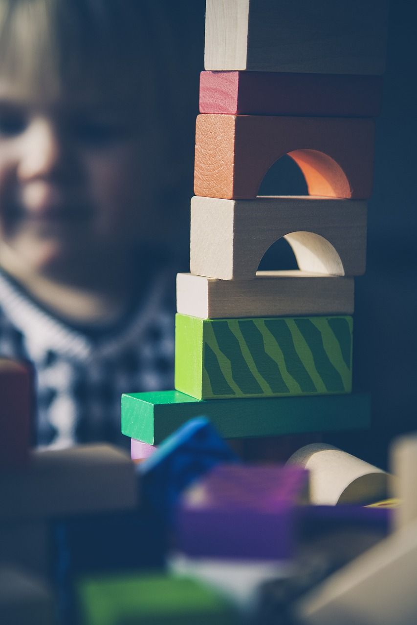 A child is playing with wooden blocks on a table.