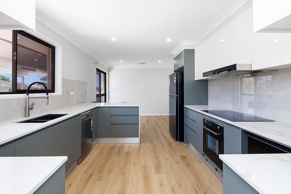 A kitchen with a sink , stove , refrigerator and dishwasher.