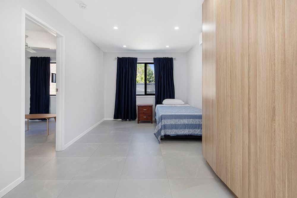 A bedroom with a bed , nightstand , and window.