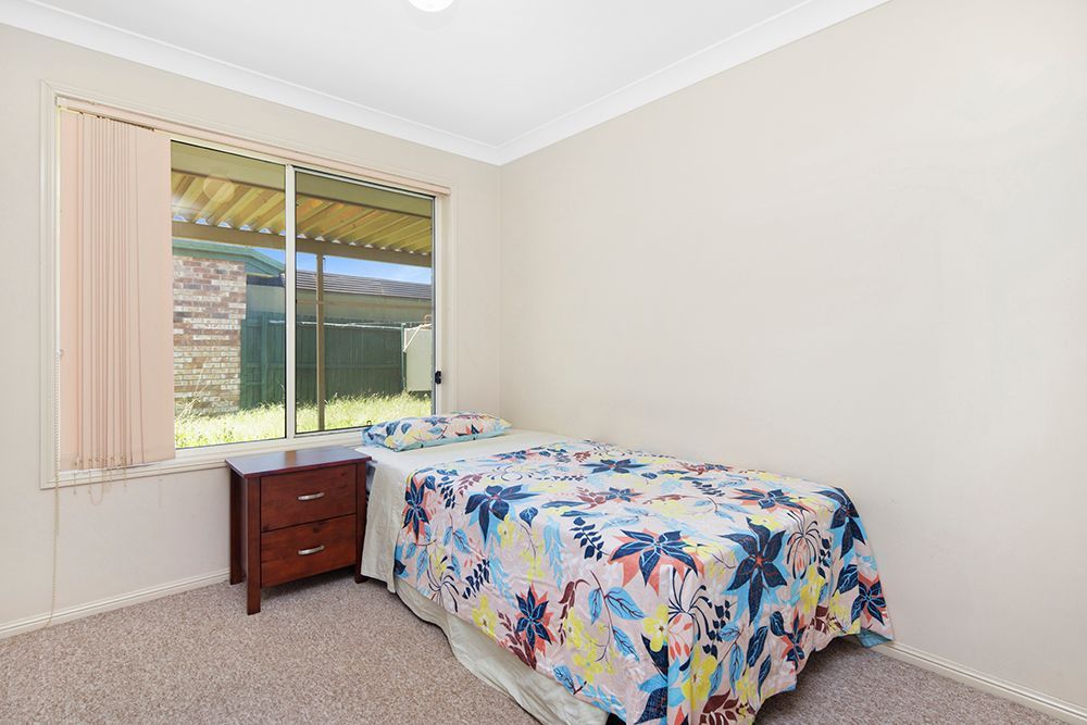 A bedroom with a bed , nightstand , and window.