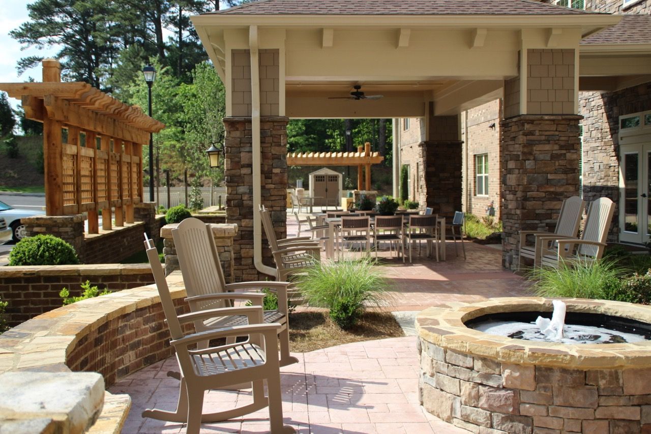 Outdoor community courtyard with seating, stone pillars, and a fountain under a covered area.