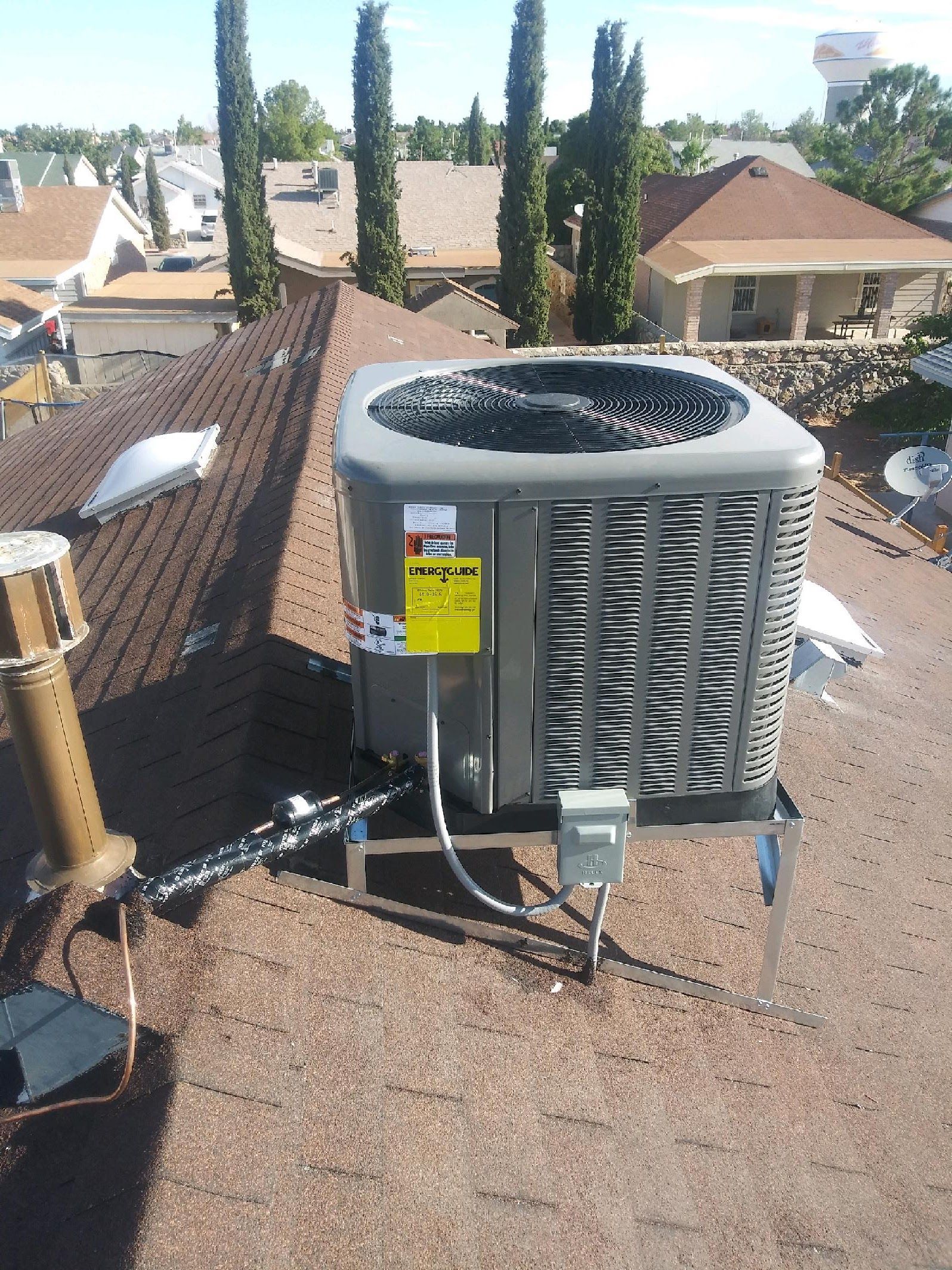 Central air conditioning unit on a brown rooftop.