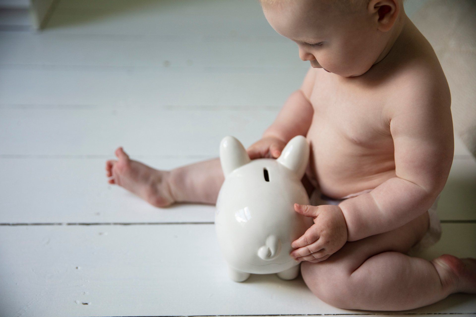 baby holding on to a piggy bank