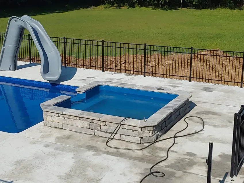 A swimming pool with a slide and a hot tub