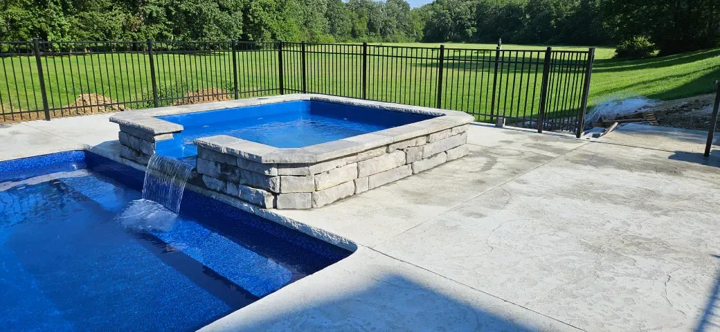 A large swimming pool with a waterfall in the middle of it.