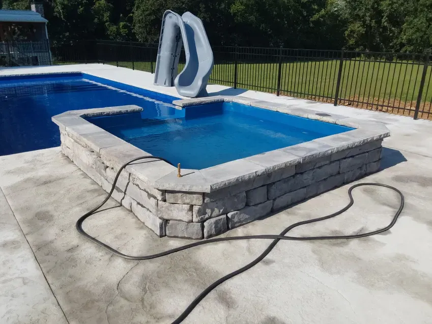 A hose is attached to the side of a swimming pool