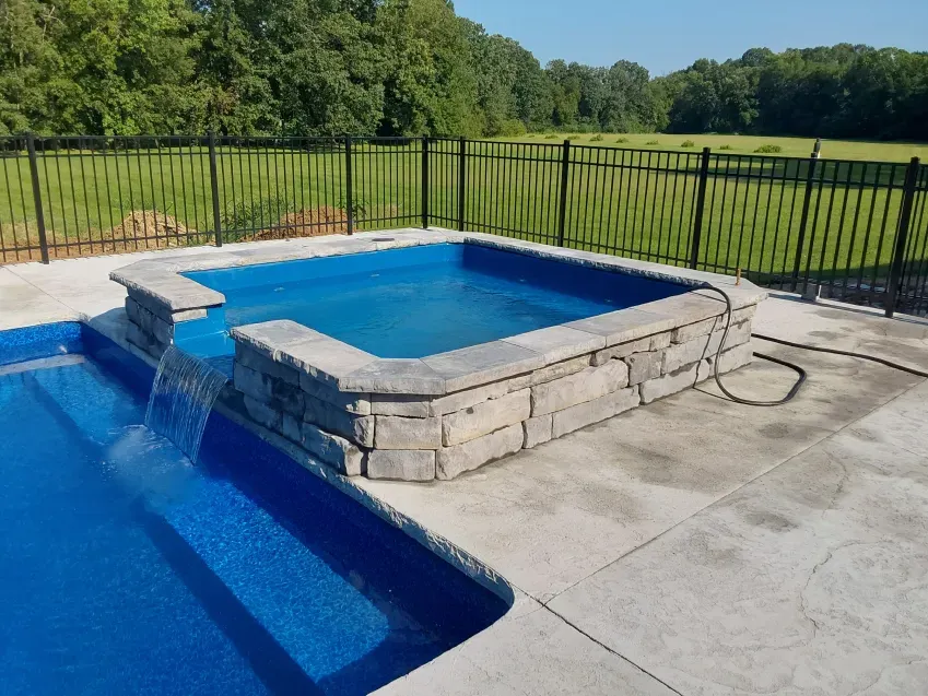 A swimming pool with a waterfall in the middle of it