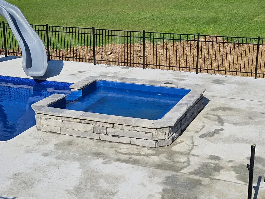 A swimming pool with a slide and a hot tub