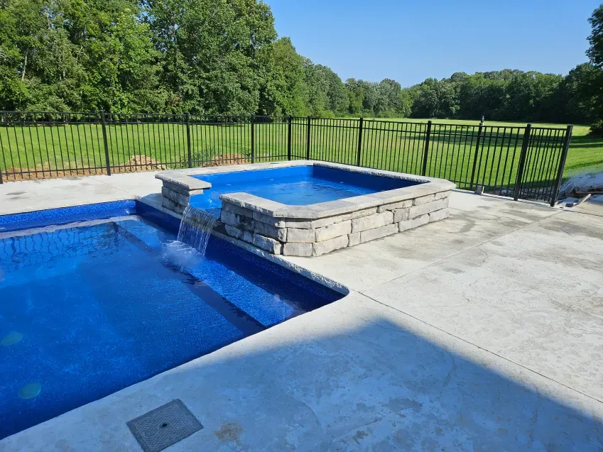 A large swimming pool with a waterfall in the middle of it.