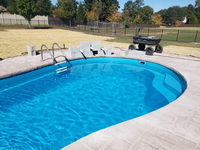 A large swimming pool with a ladder in it
