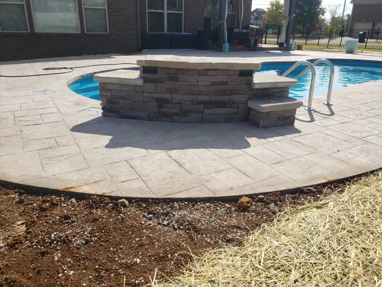 A swimming pool with steps leading to it in front of a house