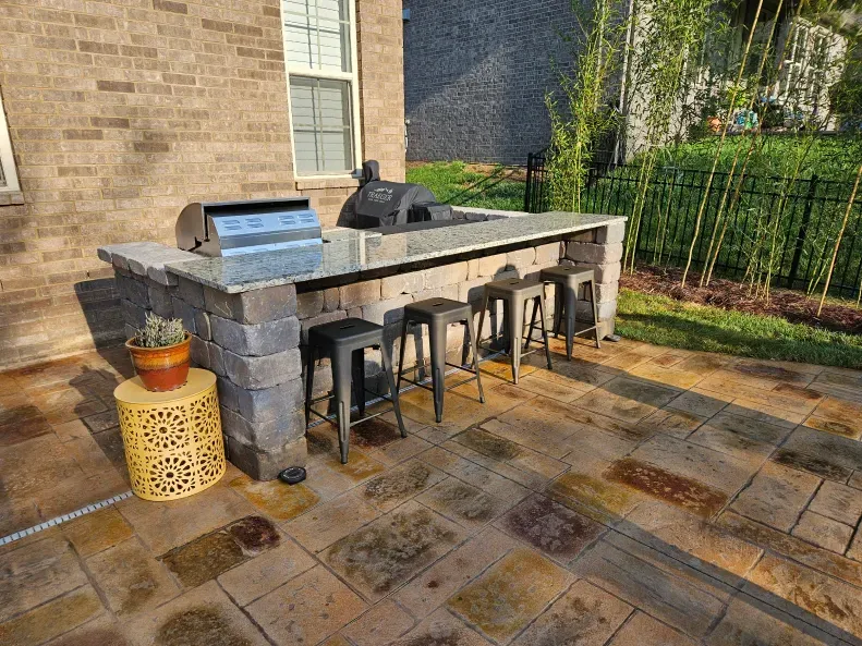 There is a grill and stools on the patio.