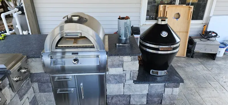 There is a pizza oven and a grill in the kitchen.