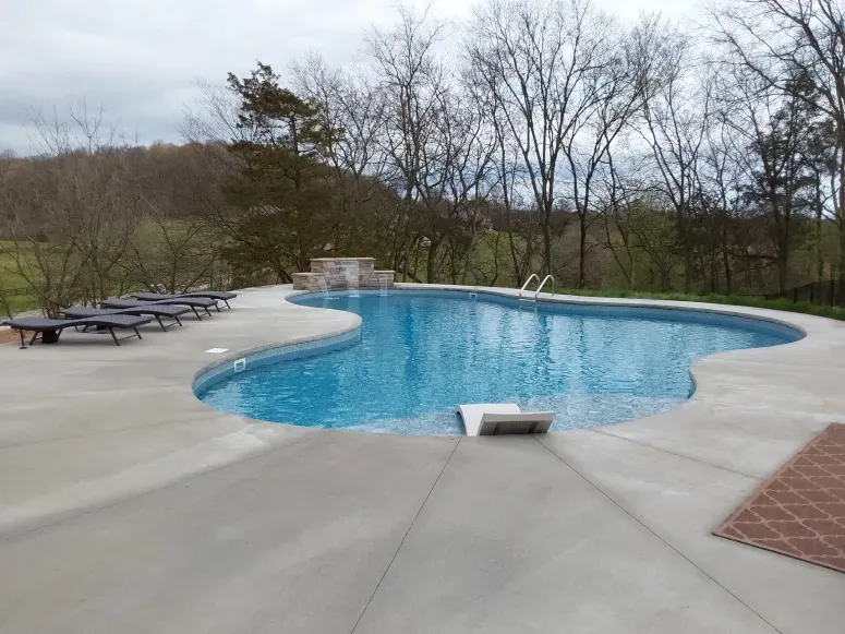 A large swimming pool with a lot of chairs around it