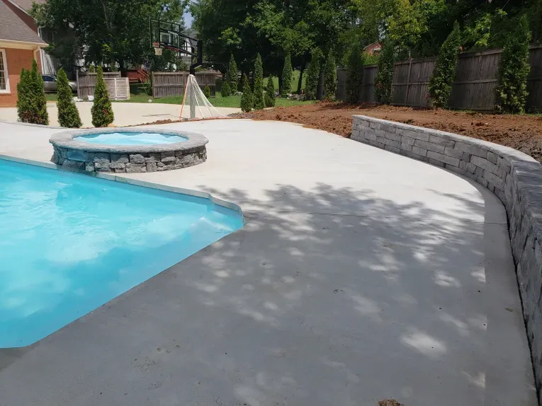 A swimming pool with a hot tub in the backyard.
