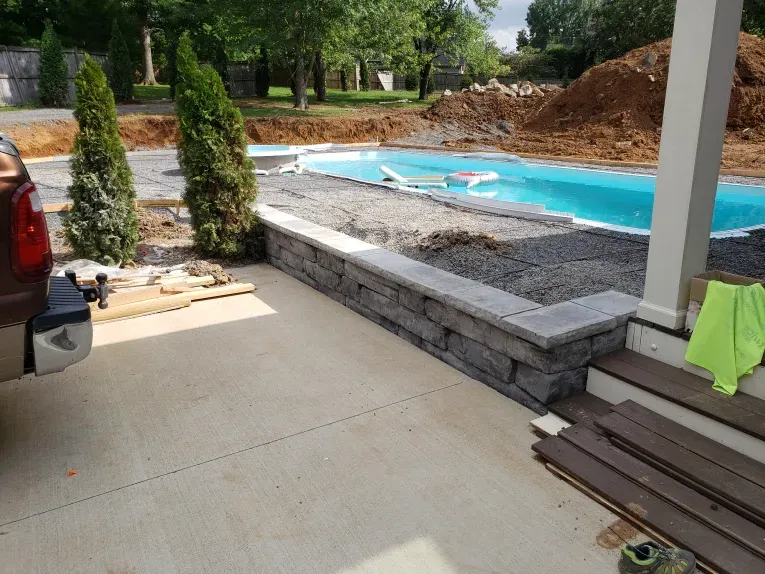 A truck is parked in a driveway next to a pool.