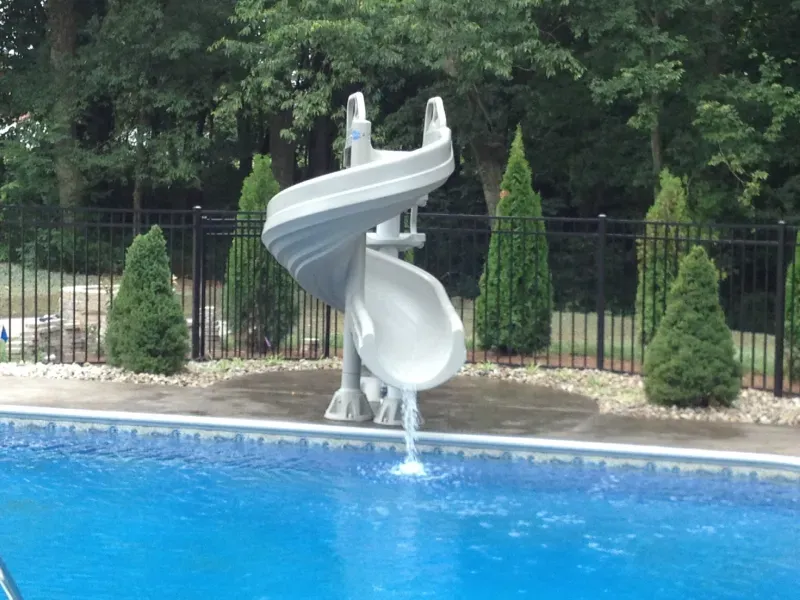 A water slide is in the middle of a swimming pool